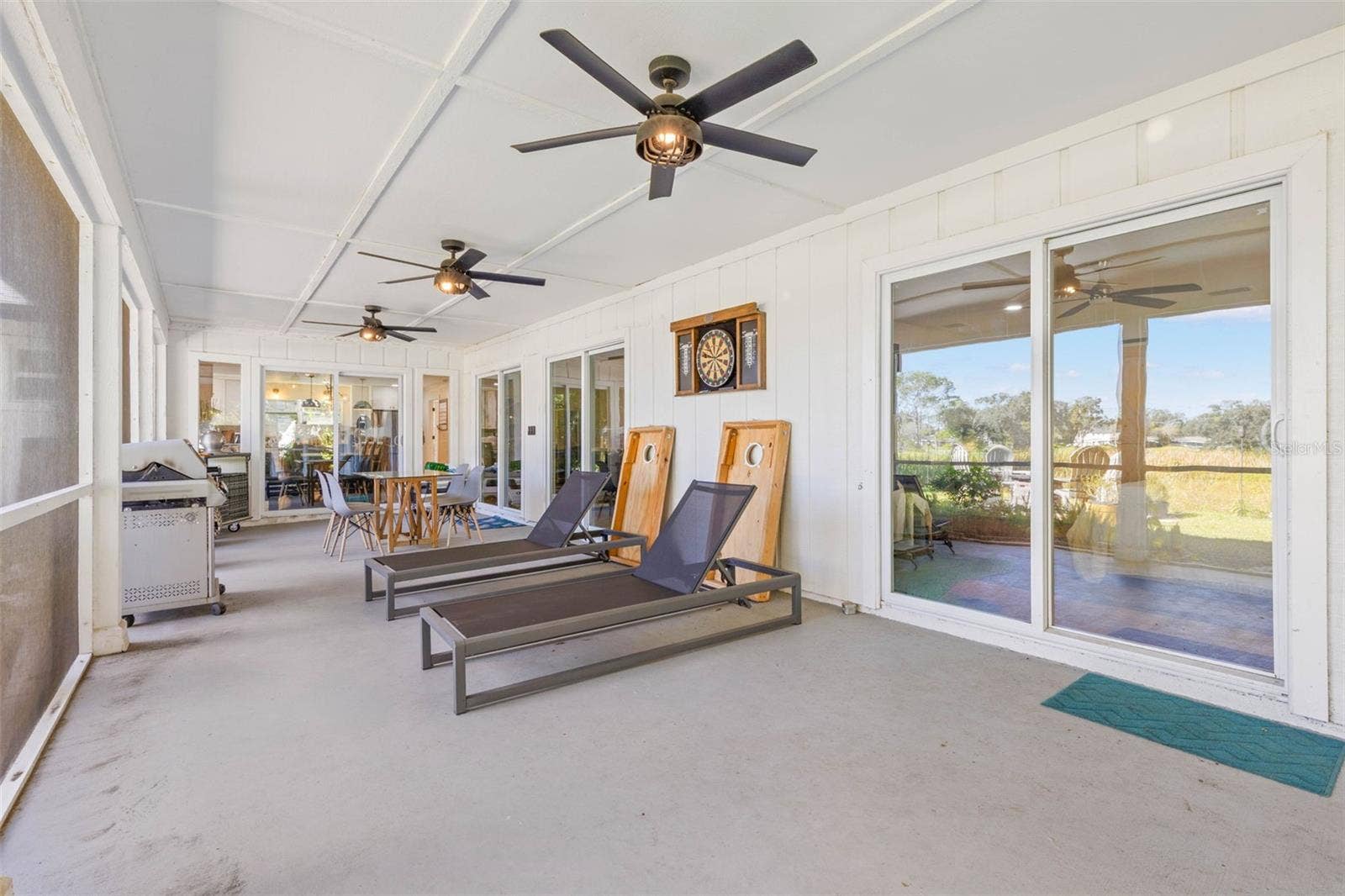3013 GRAHAM LANE, Tampa, FL 33618 An impressive screened porch extends across the back of the home, offering plenty of room for outdoor dining, lounging, and entertaining. Three ceiling fans provide added comfort, while multiple sliding glass doors connect this versatile retreat to the interior living spaces.