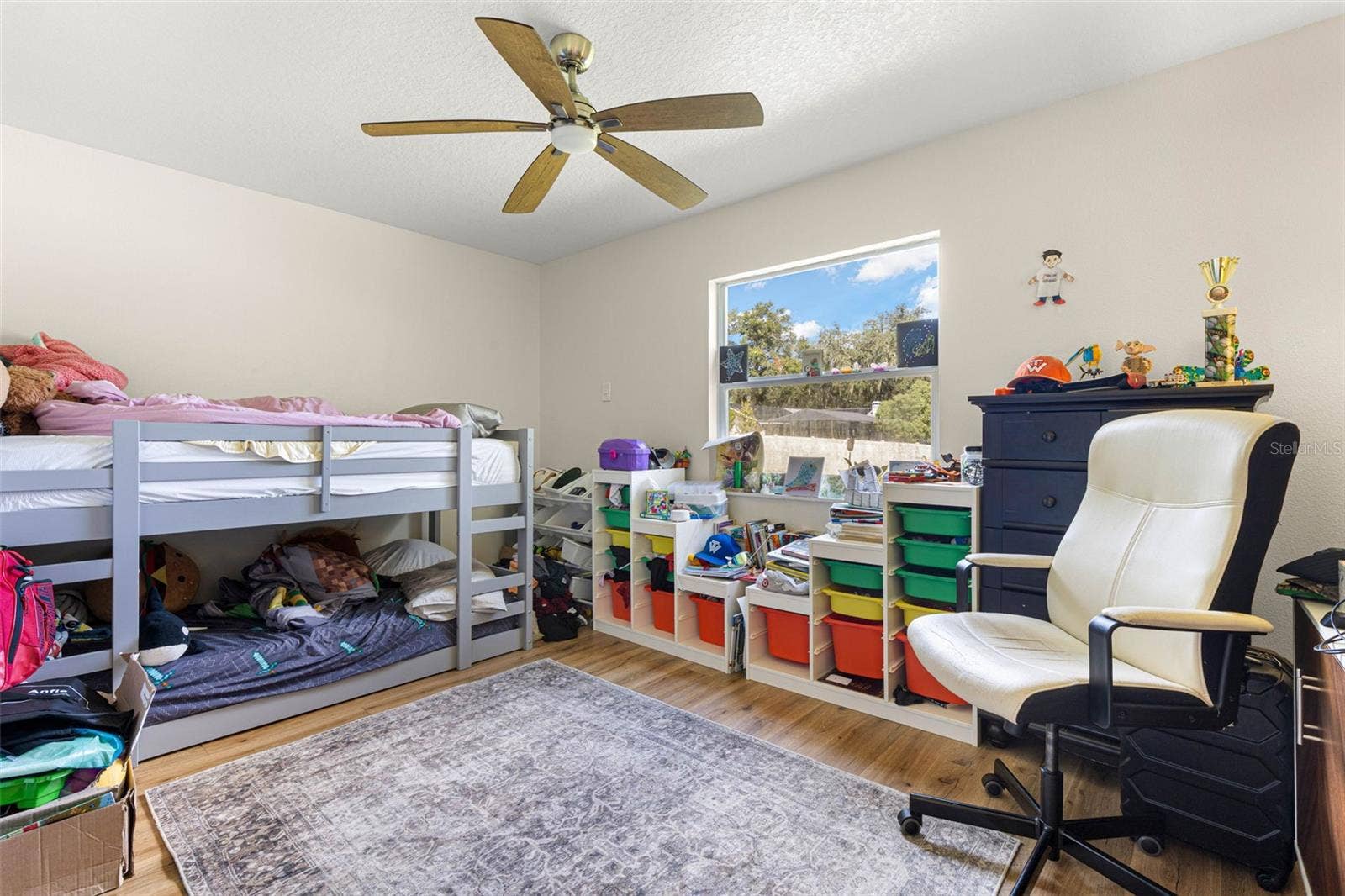 3013 GRAHAM LANE, Tampa, FL 33618 Bedroom two offers a comfortable layout with wood-look luxury vinyl flooring, a contemporary ceiling fan, and a large window that welcomes natural light. Easily adaptable as a guest bedroom, home office, or creative space to suit your needs.