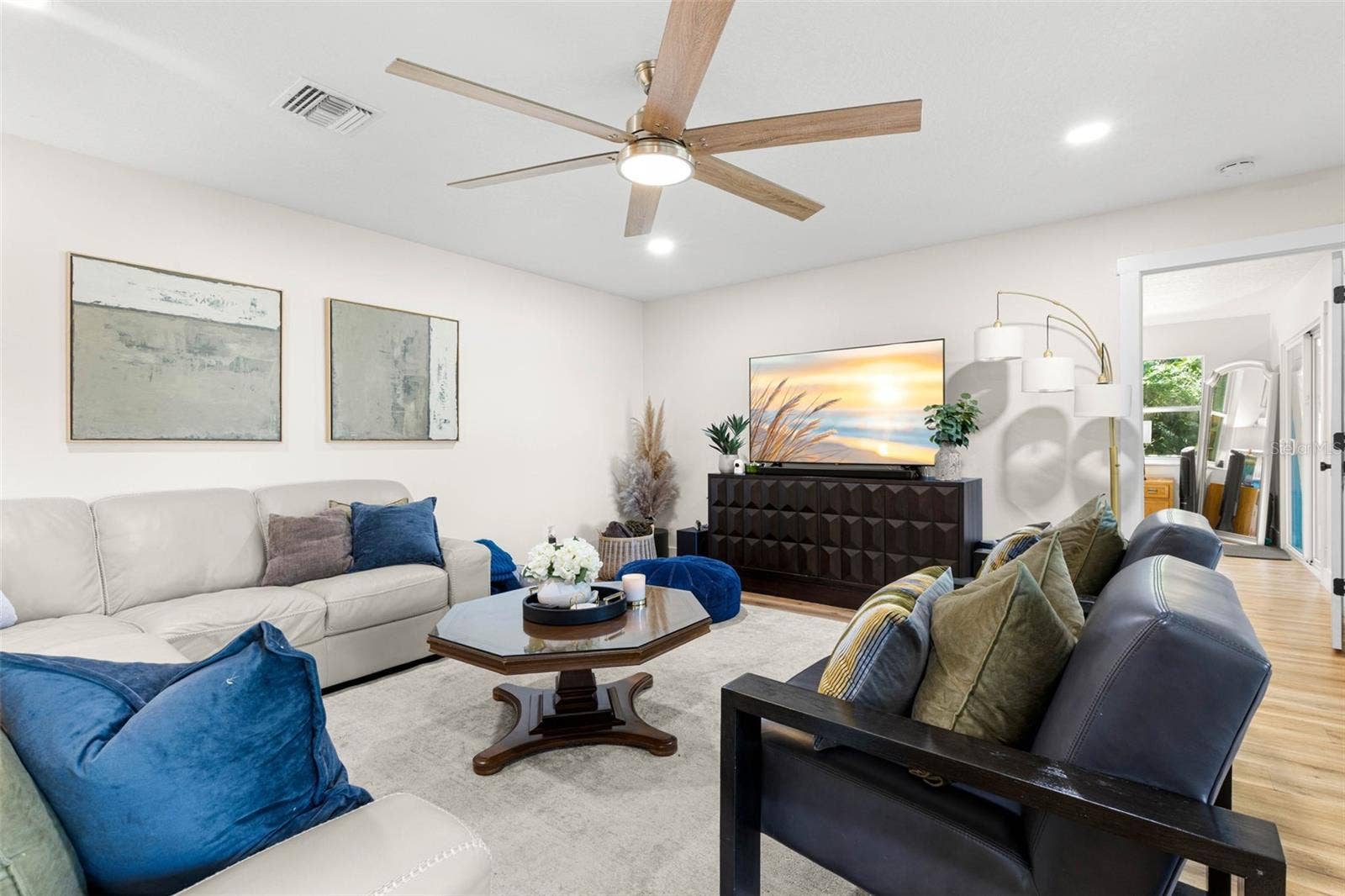 3013 GRAHAM LANE, Tampa, FL 33618 Another perspective of the spacious living room highlights its comfortable layout, generous seating area, recessed lighting, and contemporary ceiling fan with wood-tone blades. An inviting space for relaxing with family or entertaining guests.