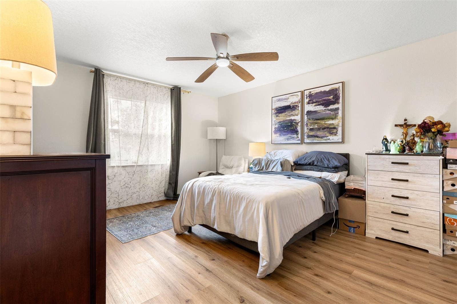 3013 GRAHAM LANE, Tampa, FL 33618 Bedroom three offers a generously proportioned layout with warm wood-look luxury vinyl flooring, a contemporary ceiling fan, neutral walls, and a large window that welcomes natural light. Plenty of room for a full bedroom furniture arrangement without feeling crowded.