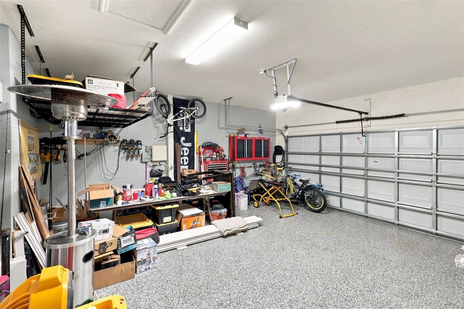 33310 MAJOR OAK DRIVE, Wesley Chapel, FL 33545 Garage Showcasing Epoxy-Coated Flooring and Ample Storage Space
