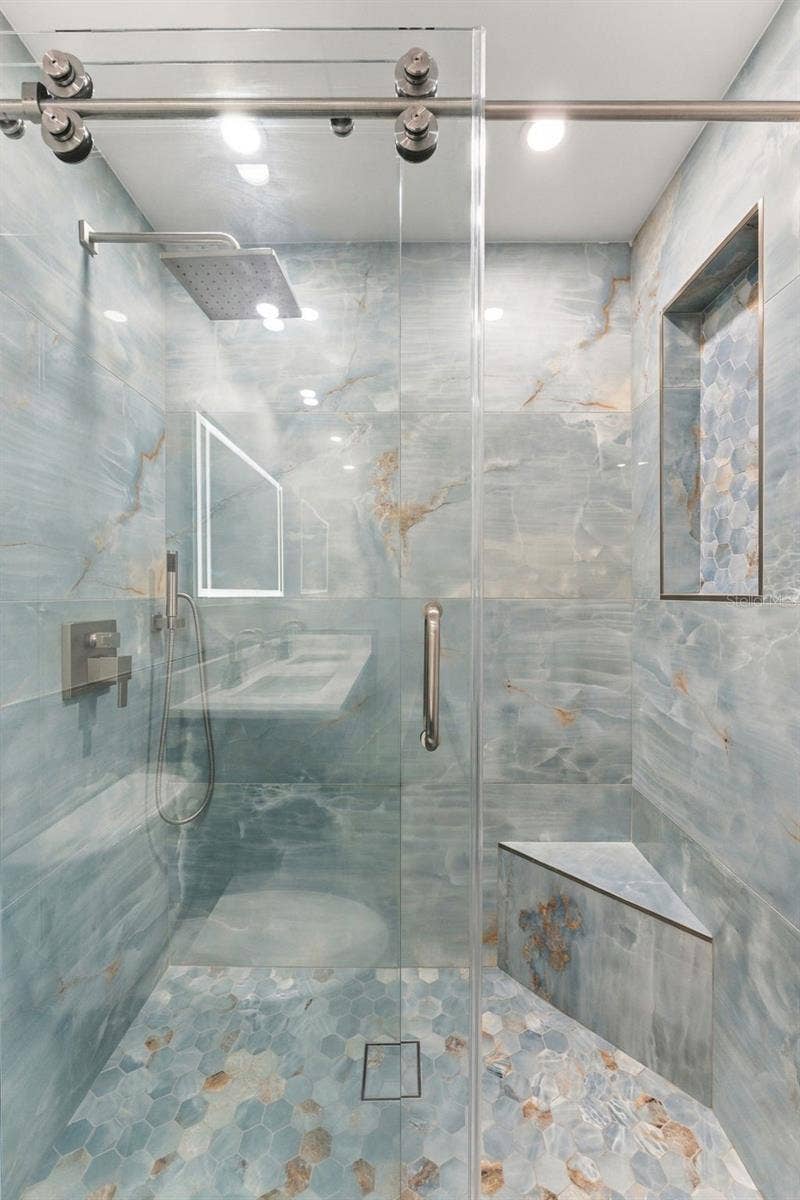 Beautiful primary shower with large glass bypass doors and modern finishes