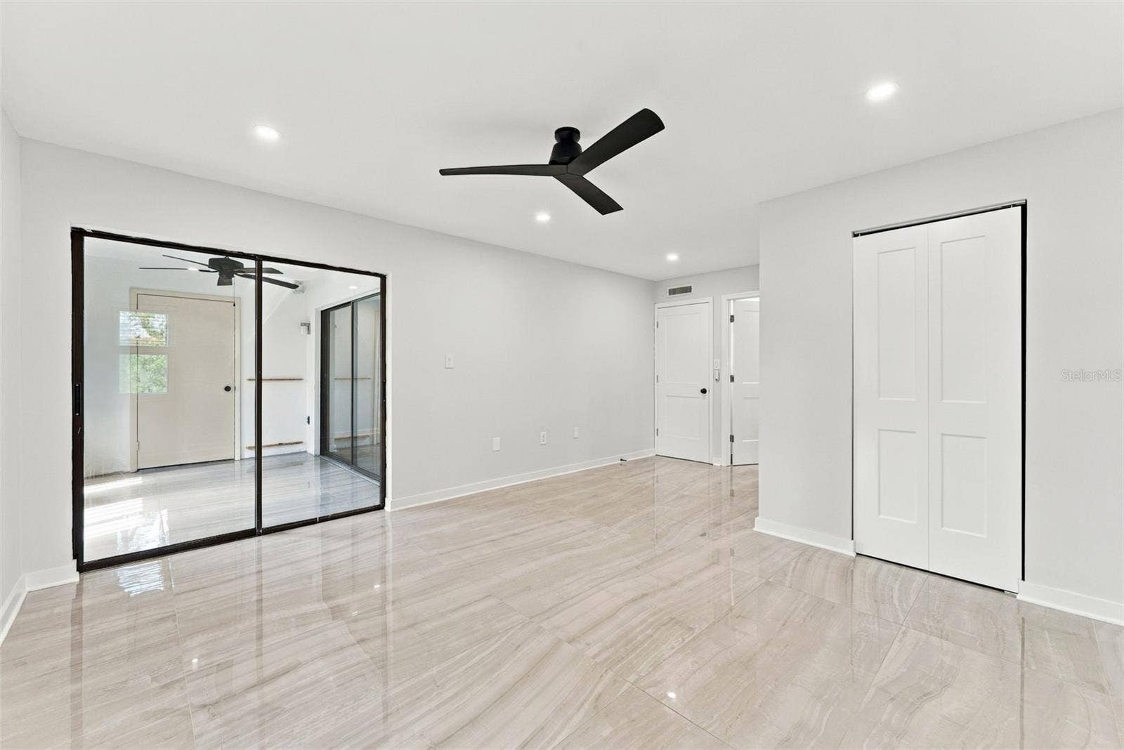 Primary bedroom with sliding glass doors opening to the patio