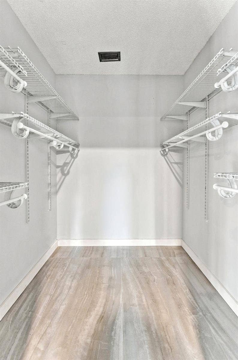 Walk-in primary closet offering plenty of storage space