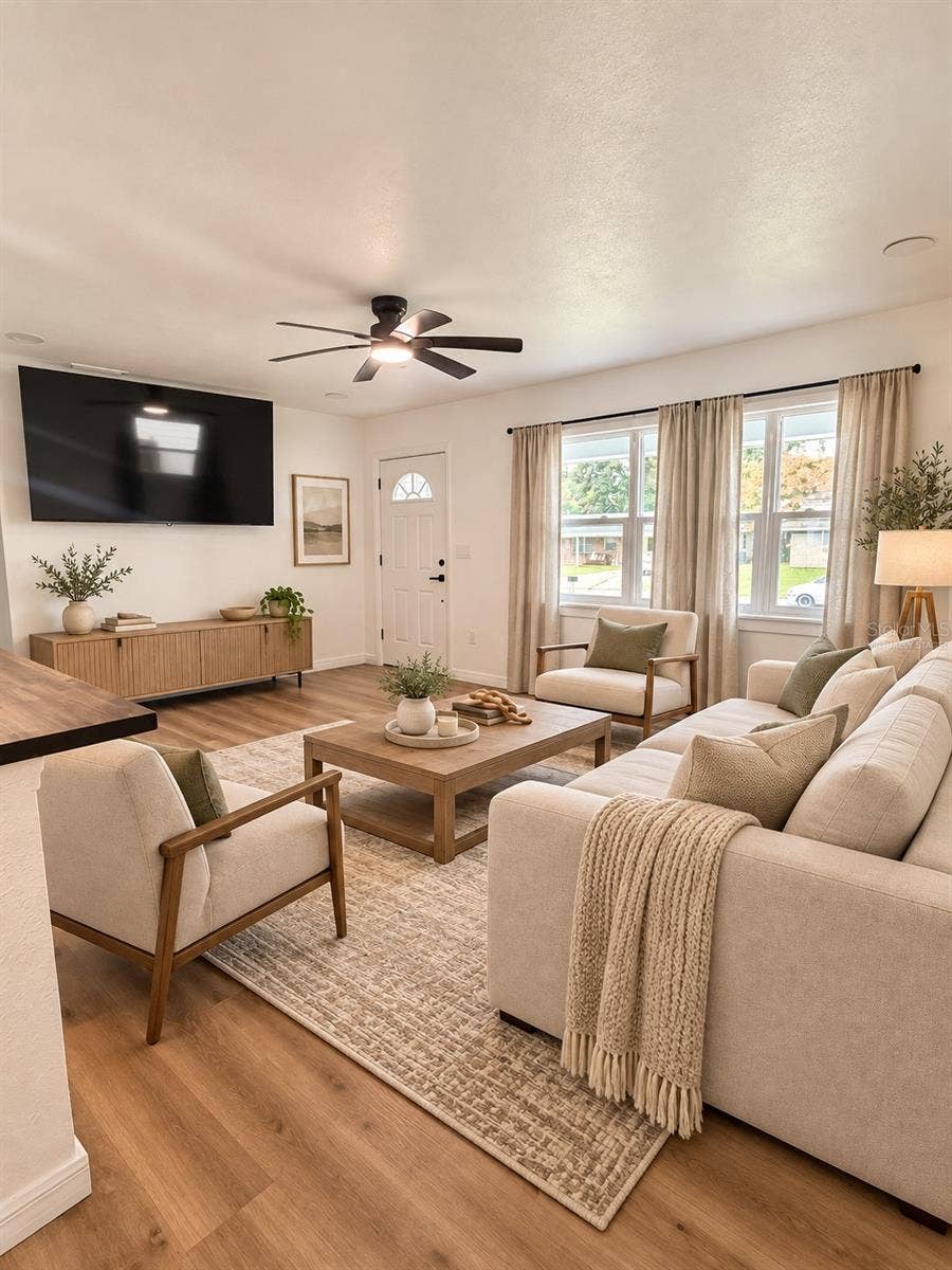 120 HAWTHORNE ROAD, Winter Haven, FL 33884 Virtually staged living room showcasing a comfortable seating arrangement and inviting space for entertaining.