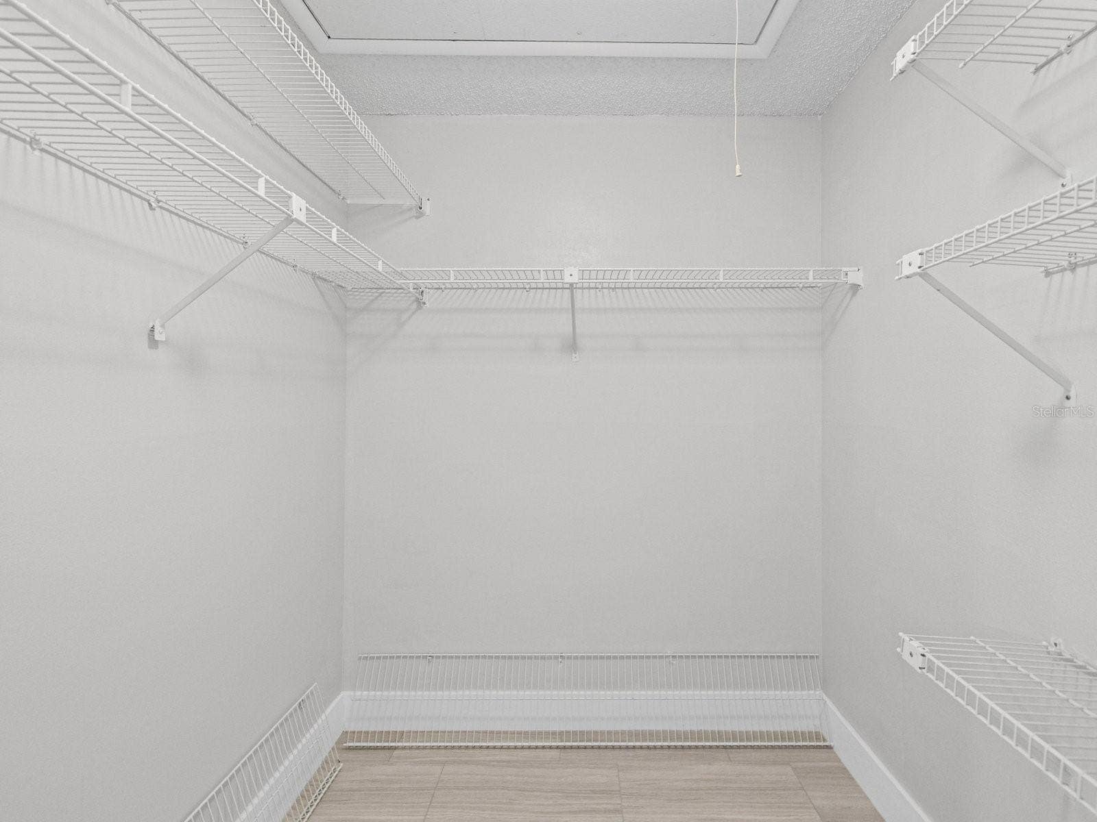 Large walk in closet with pull down stairs to storage above