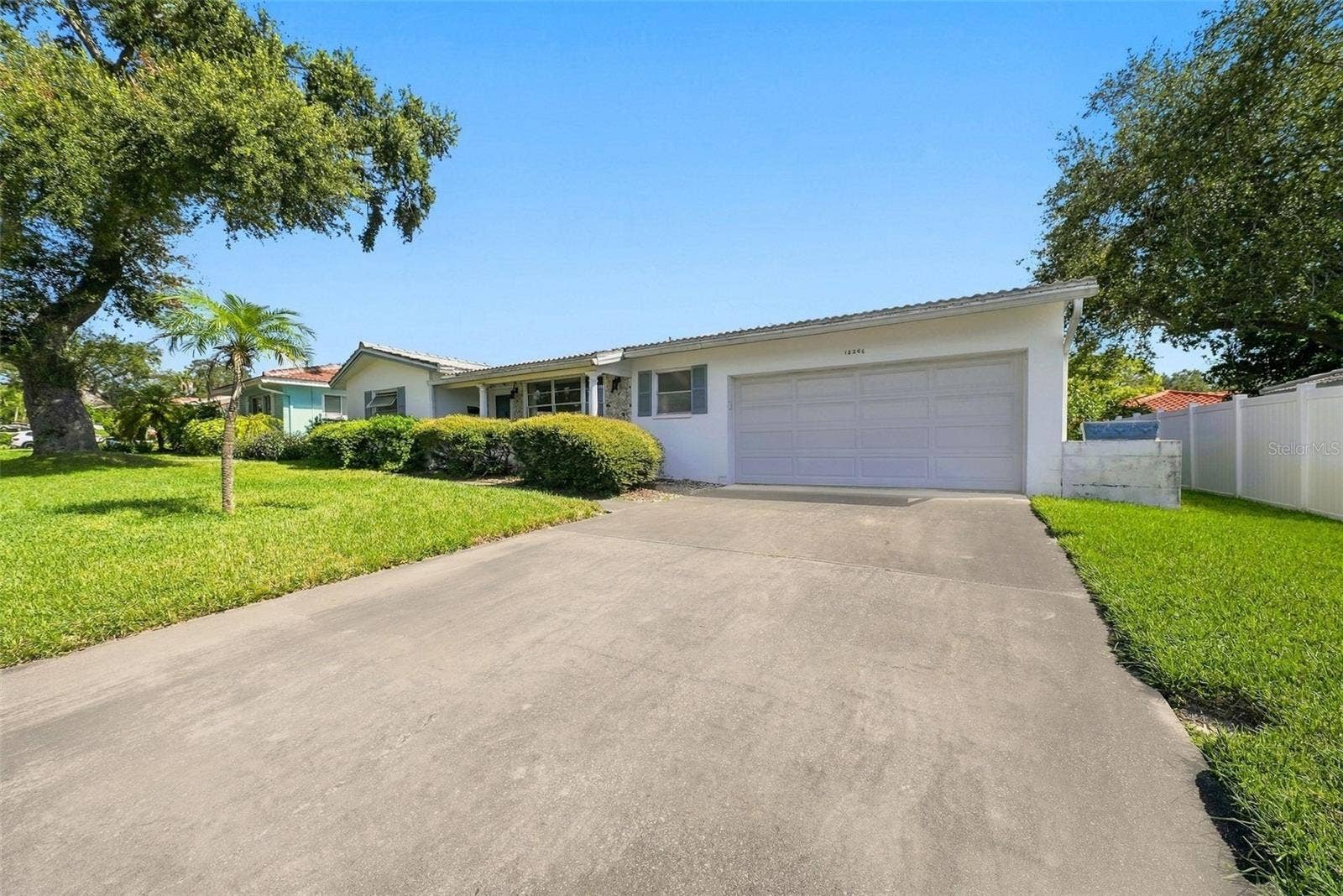 12266 69TH TERRACE, Seminole, FL 33772 Front exterior view featuring extended concrete driveway and attached garage with well maintained lawn