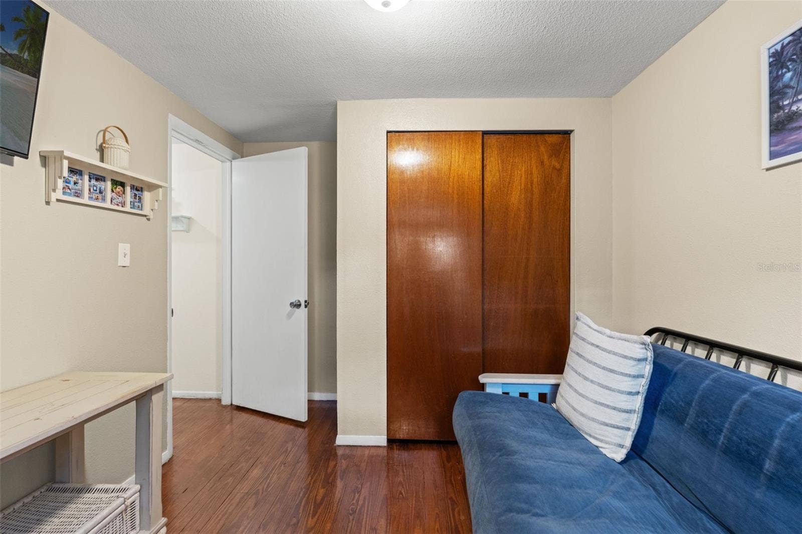 A second view of this versatile room highlights the built-in closet and warm wood flooring. Whether used for guests, hobbies, or a home office, this additional space offers practical flexibility.