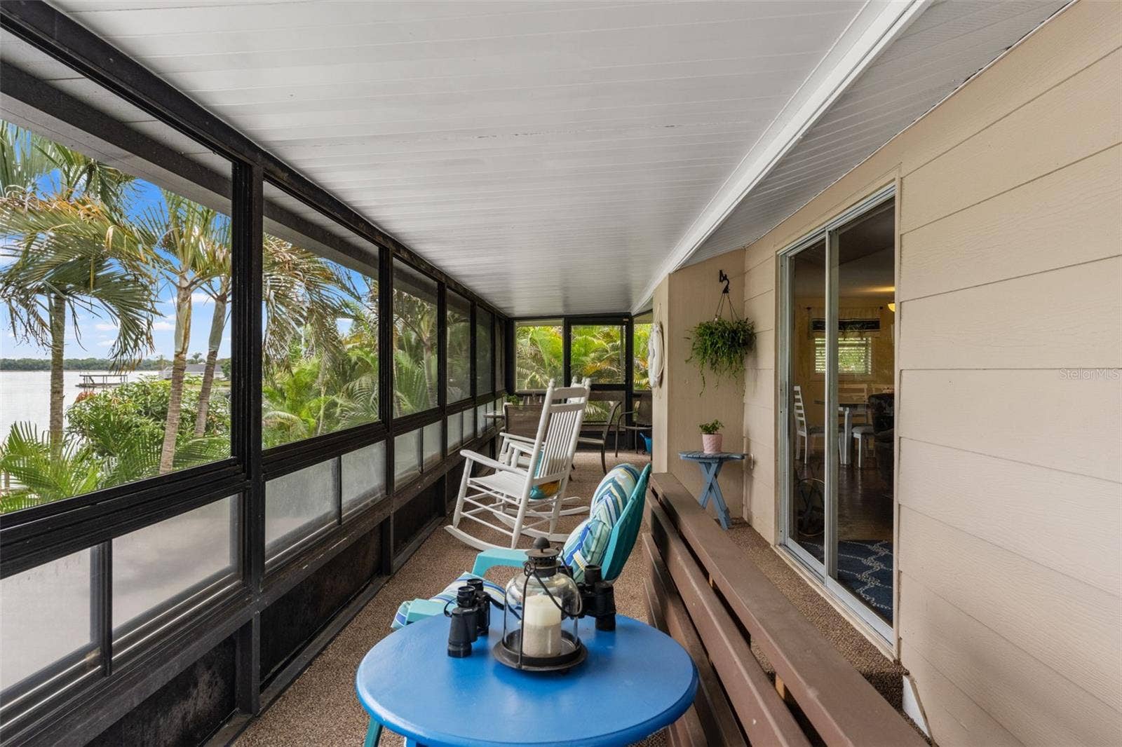 Imagine starting your mornings here! This long, screened porch overlooks the water and surrounding palms, with plenty of room for rocking chairs, conversation, and quiet relaxation. Sliding glass doors provide convenient access to the main living area.