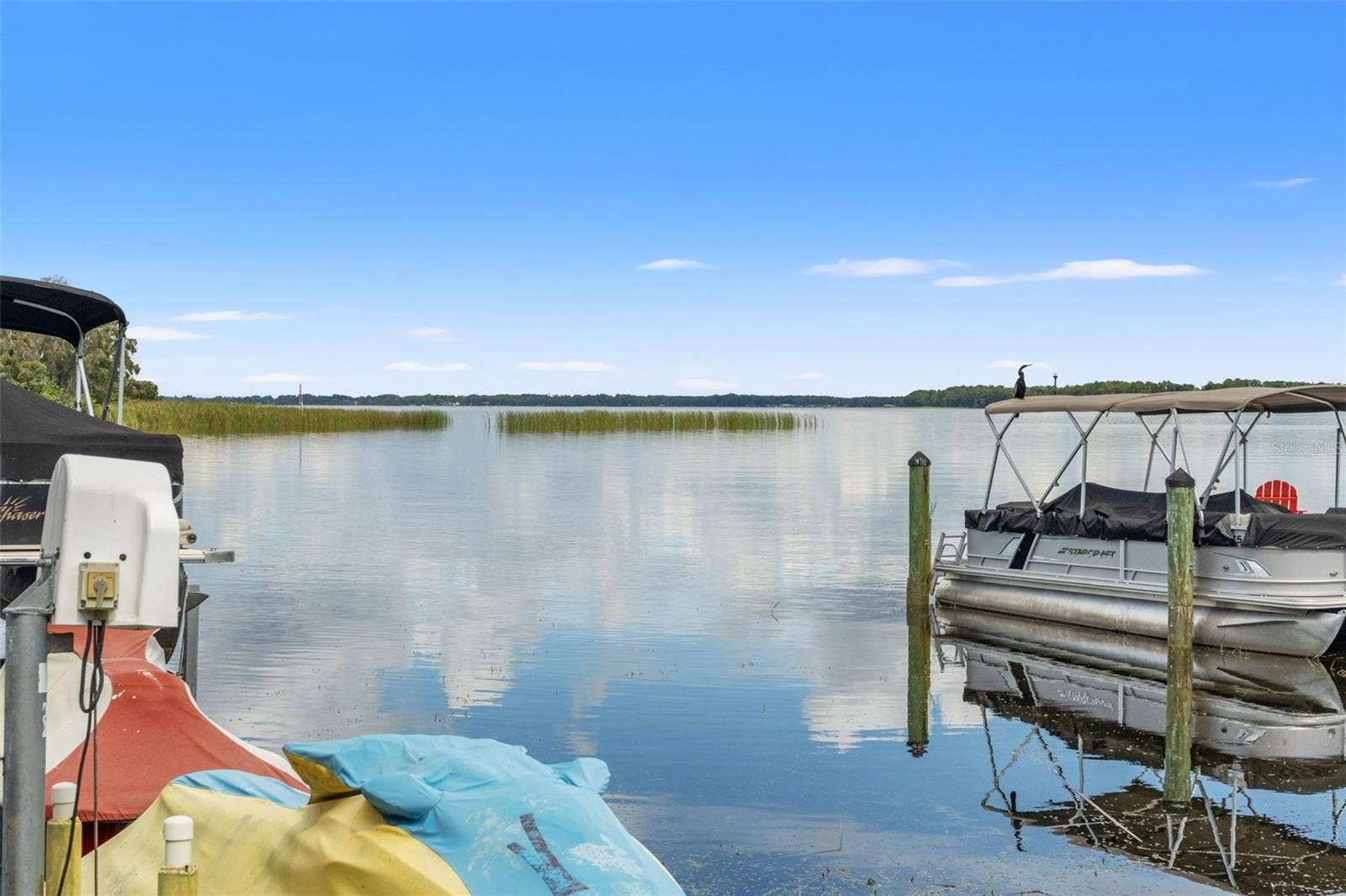 Wide-open water, peaceful surroundings, and beautiful Florida skies. Enjoy expansive lake views from the dock, with natural shoreline vegetation and distant tree-lined banks creating a scenic backdrop. A wonderful setting for boating, fishing, or simply appreciating the waterfront.