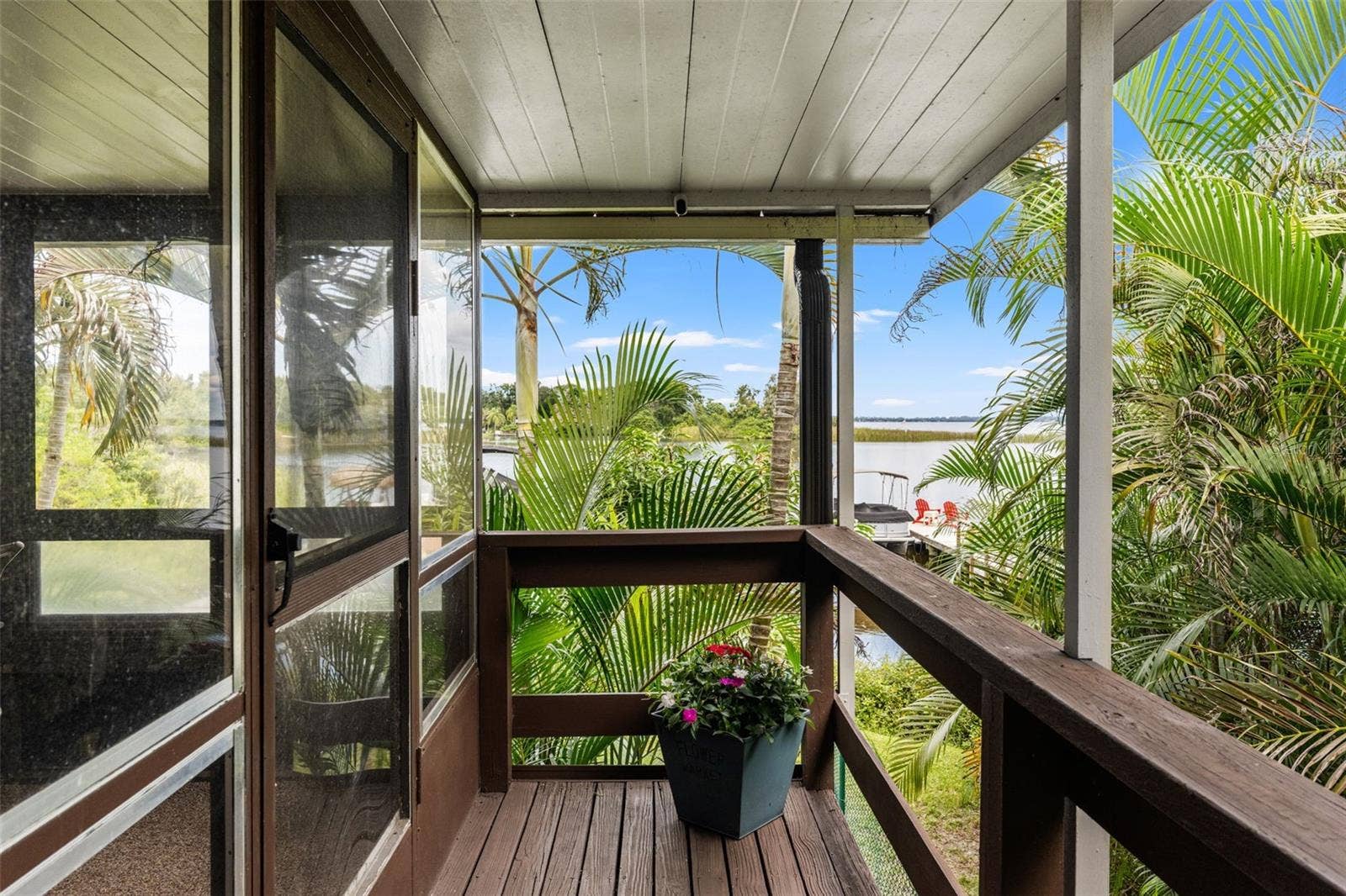 Your first glimpse of the waterfront! From the covered upper-level entry, enjoy views through the palms toward the water and private docka beautiful introduction to the Florida lifestyle waiting here.