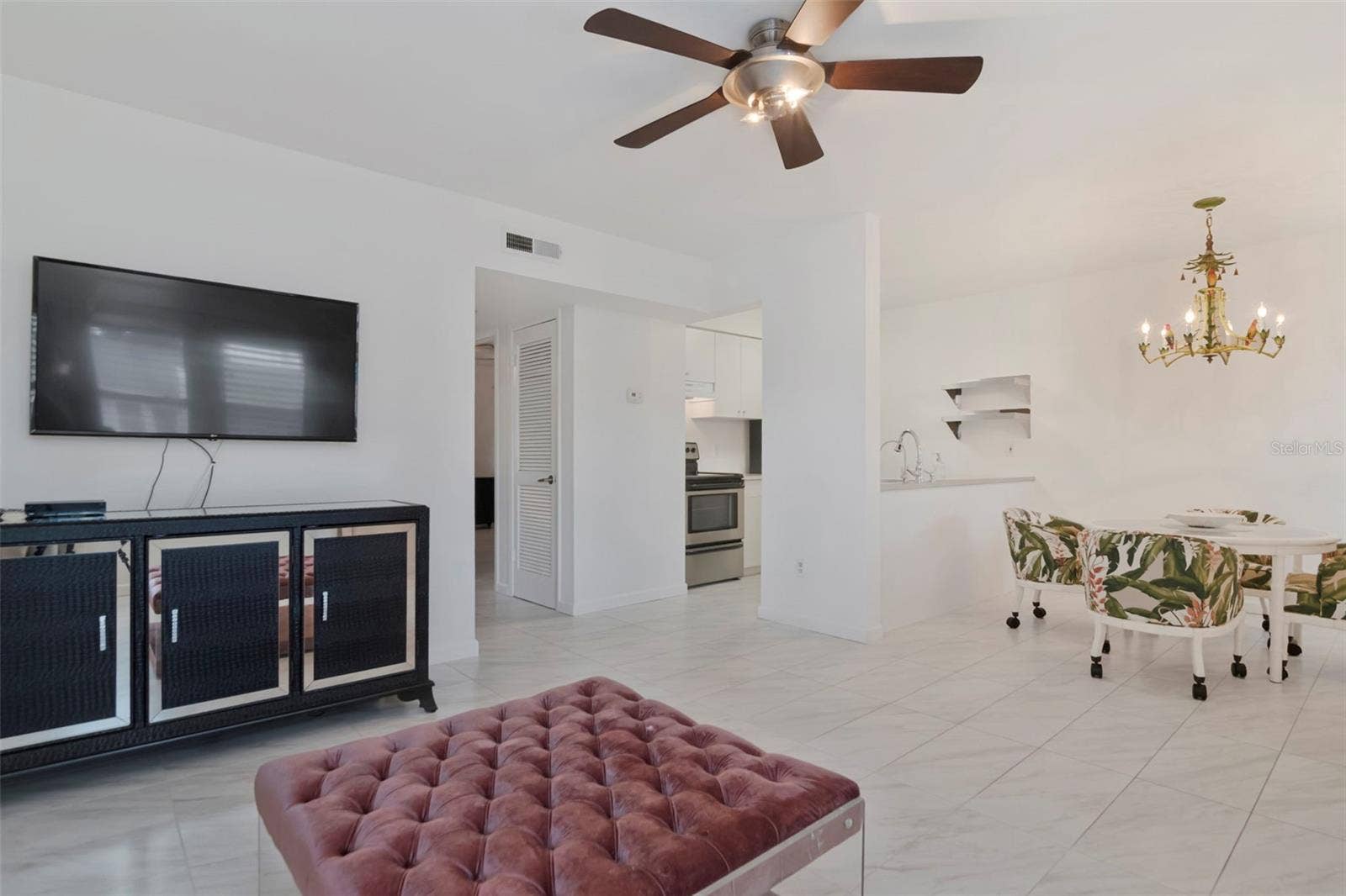 527 S LINCOLN AVENUE, #A205, Tampa, FL 33609 Open-concept living and dining area featuring tile flooring throughout, a modern ceiling fan, and stylish accent seating.