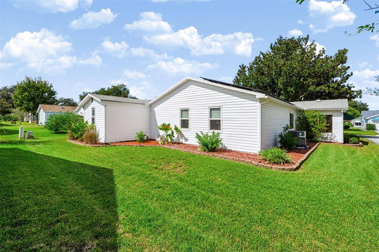 1220 MARIA COURT, Lady Lake, FL 32159 Backside of home with landscaping