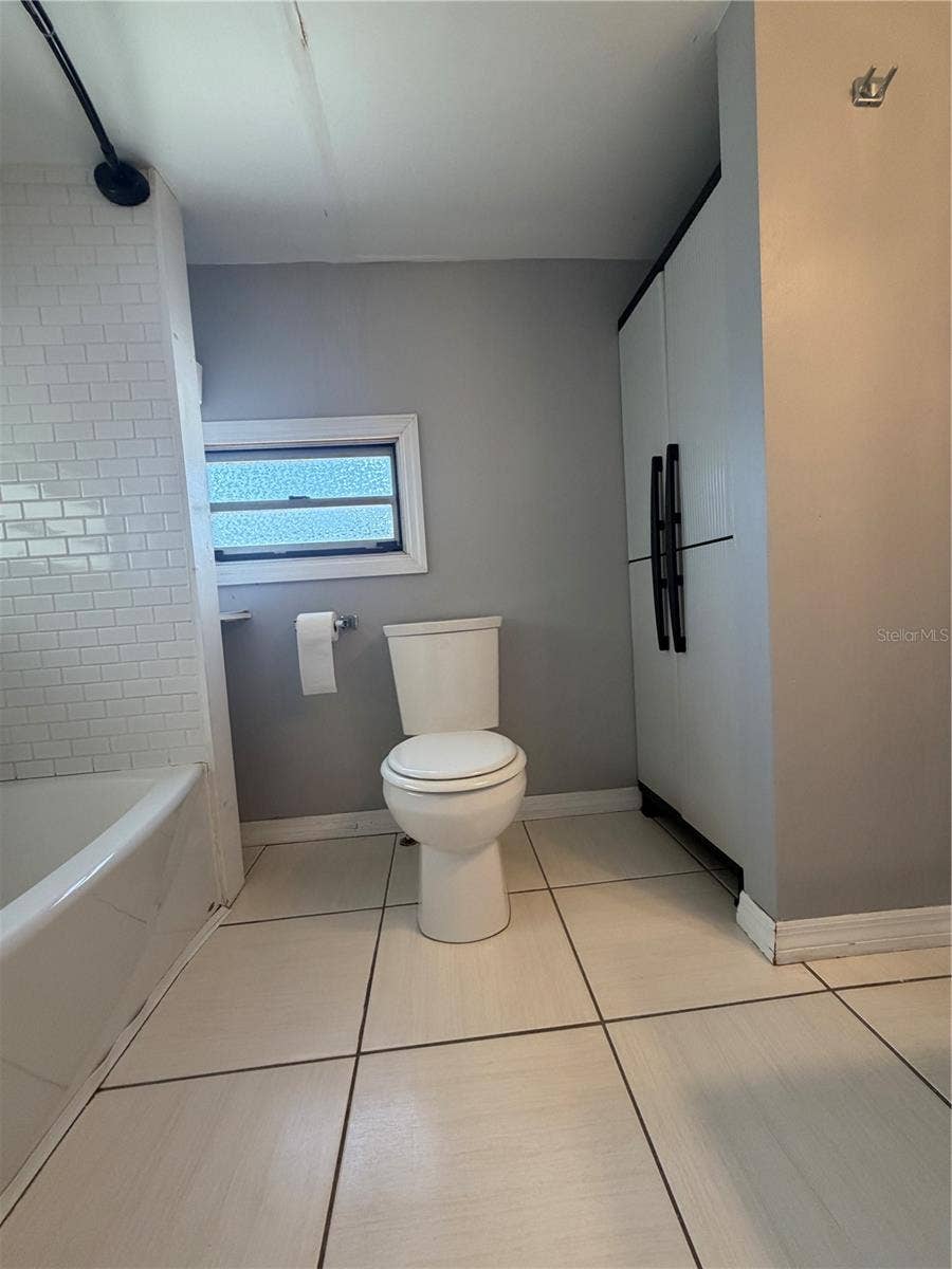 4120 BUENA VISTA LANE, Holiday, FL 34691 Bathroom with view of storage, tub/shower.