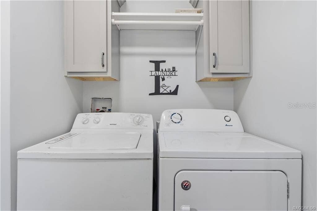 7528 N CHABAUD TERRACE, Crystal River, FL 34428 LAUNDRY MADE CONVENIENT! The INDOOR LAUNDRY AREA features a washer, dryer, overhead GRAY CABINETRY & shelving for additional storage.