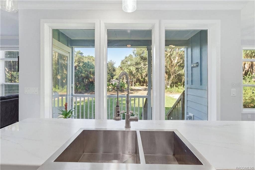 7528 N CHABAUD TERRACE, Crystal River, FL 34428 IT'S ALL IN THE DETAILS! A stylish GRAY GEOMETRIC TILE BACKSPLASH, electric cooktop & modern stainless steel range hood add personality to the kitchen.