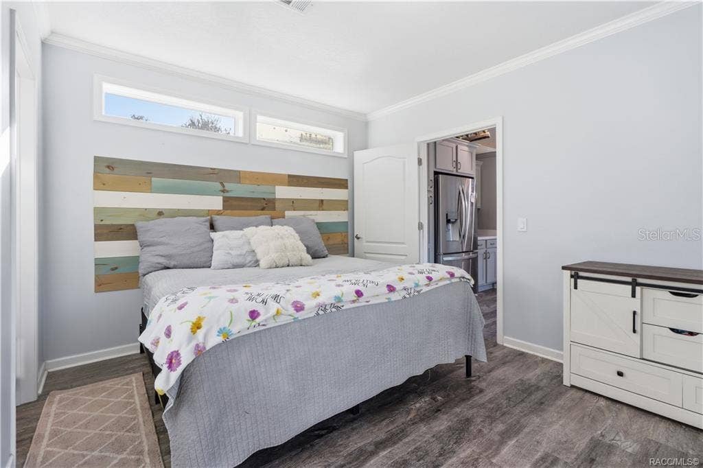 7528 N CHABAUD TERRACE, Crystal River, FL 34428 YOUR OWN COMFORTABLE RETREAT! The PRIMARY BEDROOM features beautiful natural light, neutral finishes, LUXURY VINYL PLANK FLOORING & a distinctive wood-accent headboard.