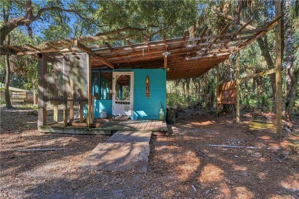 7528 N CHABAUD TERRACE, Crystal River, FL 34428 A UNIQUE OUTDOOR SPACE! A closer view of the rustic structure showcases its wooden deck, screened section & extended overhead framework.