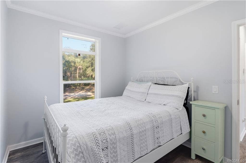 7528 N CHABAUD TERRACE, Crystal River, FL 34428 A PEACEFUL PLACE TO UNWIND! This inviting BEDROOM features soft neutral colors, attractive flooring, crown molding & a large window overlooking the beautiful natural surroundings.