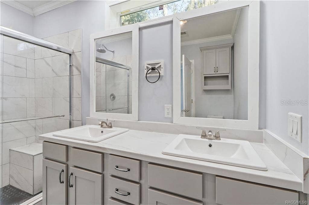7528 N CHABAUD TERRACE, Crystal River, FL 34428 A BEAUTIFULLY FINISHED PRIMARY BATH! Enjoy a DOUBLE-SINK VANITY w/GRAY CABINETRY, marble-look countertops, framed mirrors & a spacious WALK-IN SHOWER.