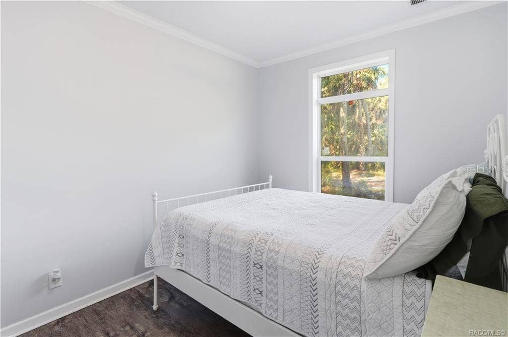 7528 N CHABAUD TERRACE, Crystal River, FL 34428 WAKE UP TO NATURE! Another view of the bedroom showcases natural light, attractive flooring & peaceful views of the surrounding trees.