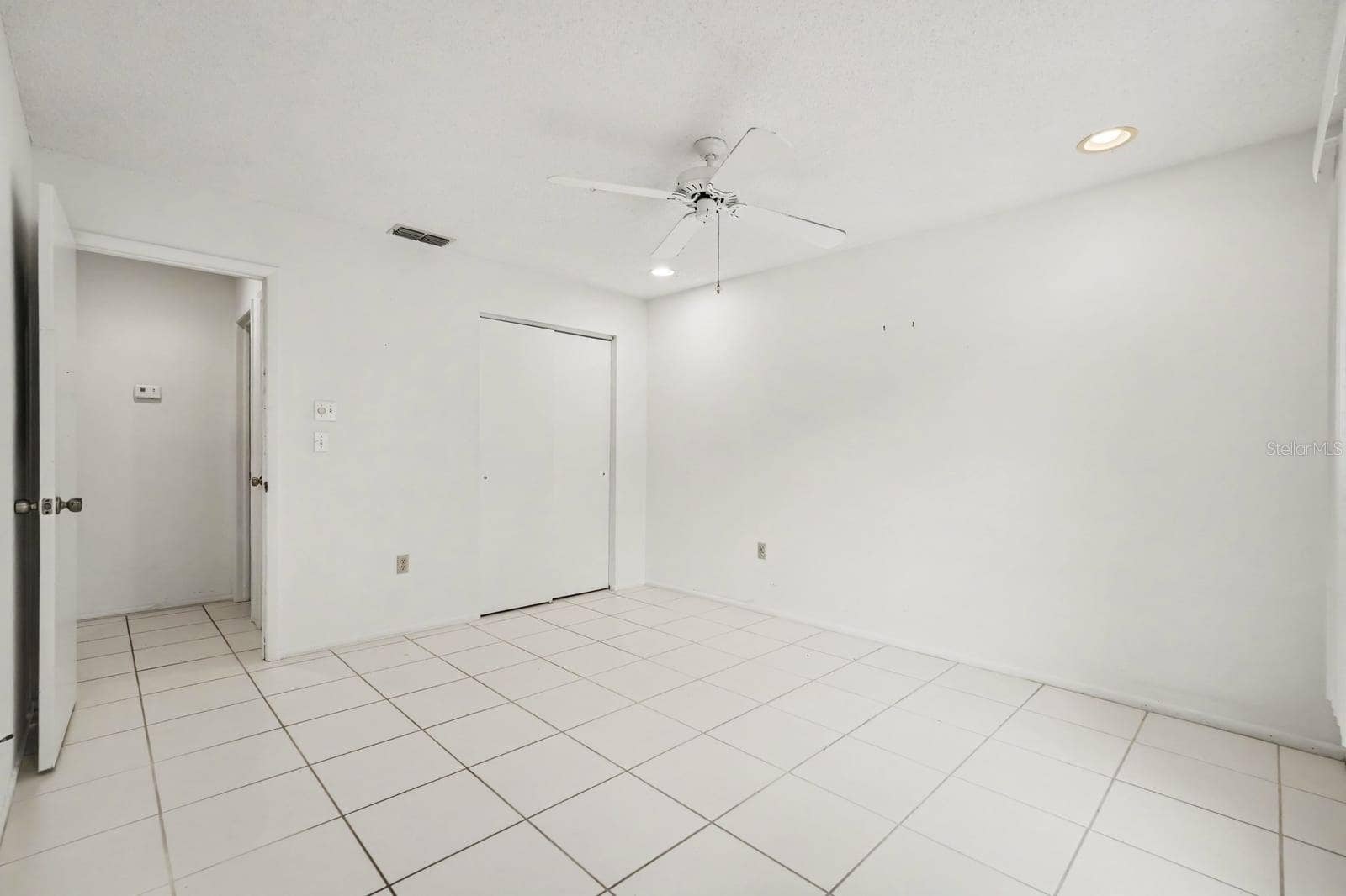 Generously Sized Bedroom with Ceiling Fan and Wall-to-Wall Tile Flooring