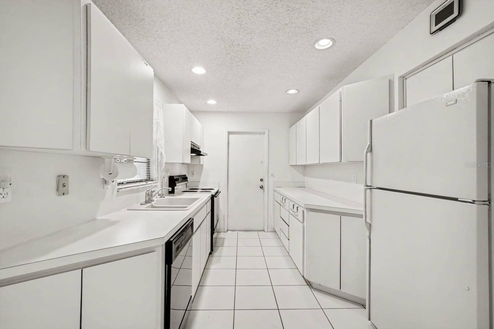 Galley Kitchen with White Cabinetry, Stainless Steel Appliances & Ample Storage