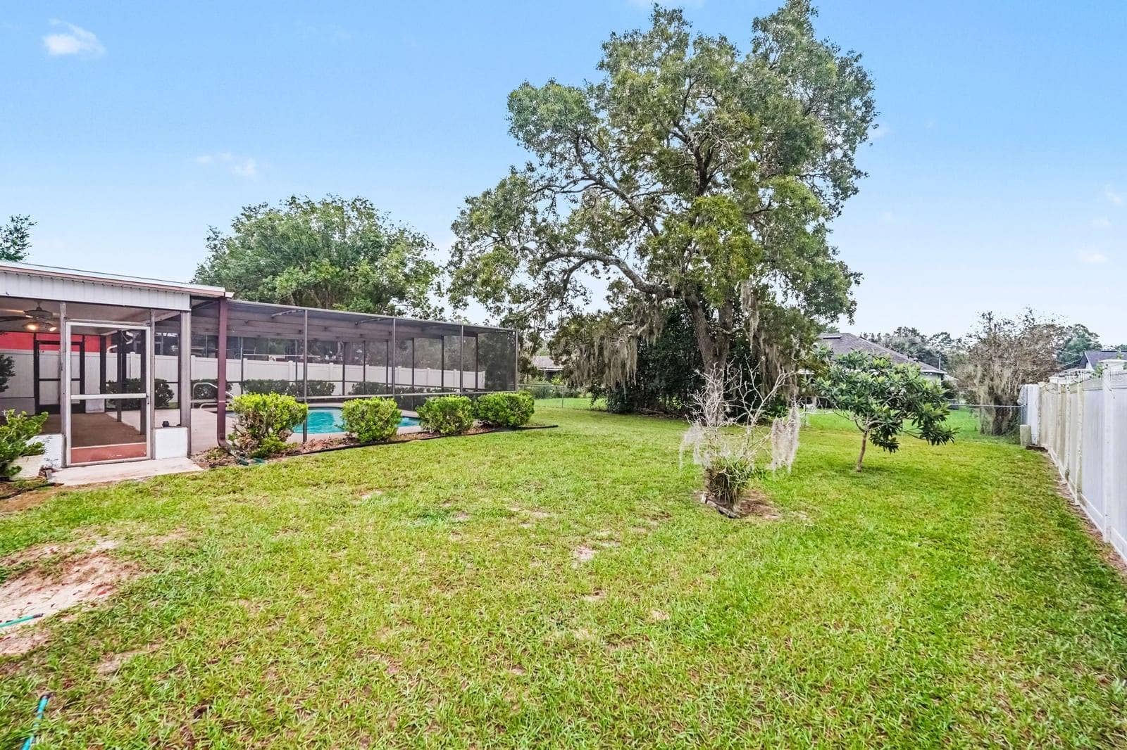 Expansive Landscaped Yard with Mature Trees and Pool Enclosure