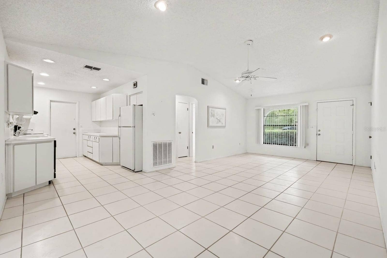 Open Concept Kitchen and Living Area with Tile Flooring and Sliding Doors