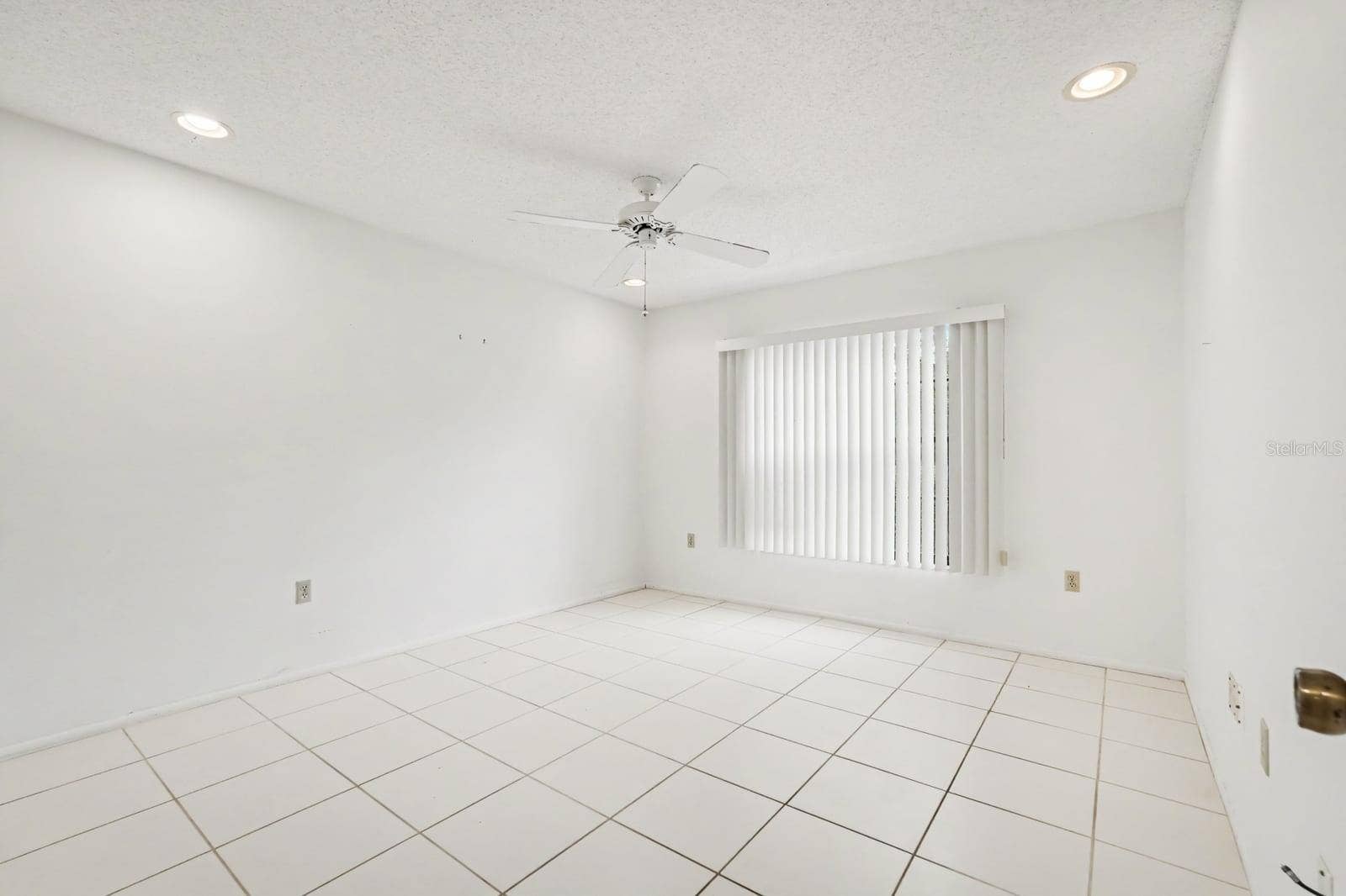 Bright Bedroom with Large Window, Ceiling Fan & Neutral Decor