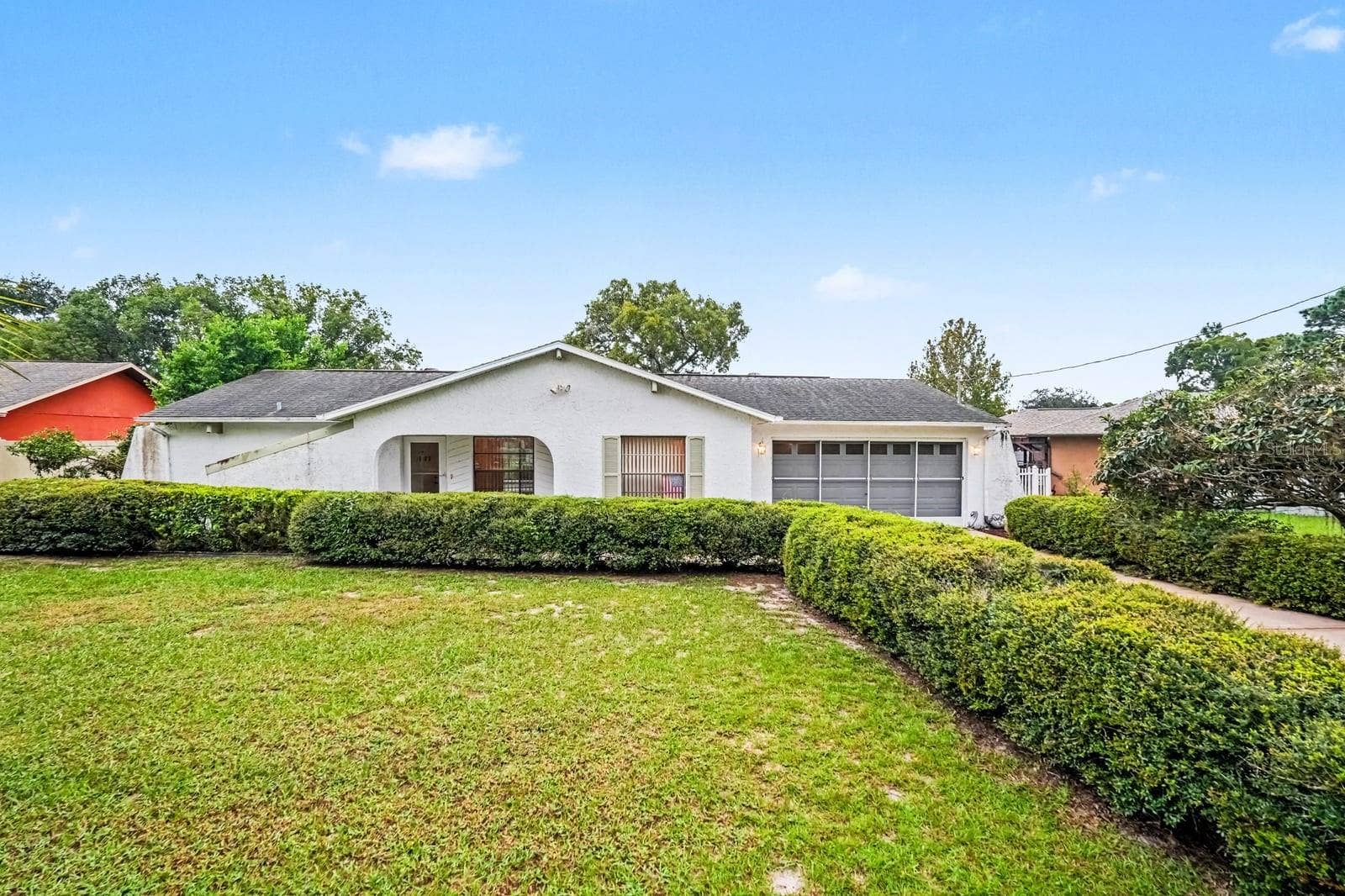 Charming White Ranch with Manicured Hedges and Spacious Lawn