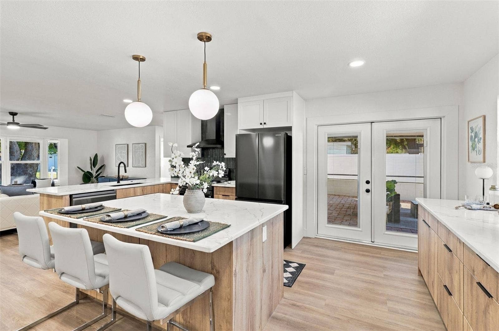 11218 116TH STREET, Seminole, FL 33778 Beautifully updated kitchen featuring quartz countertops, stainless steel appliances, and French doors leading to the outdoor living area.