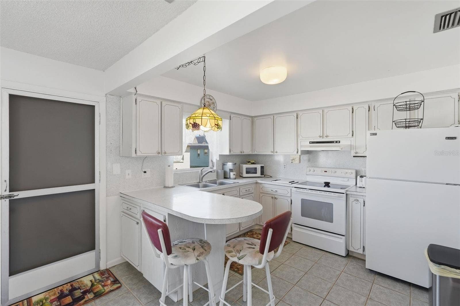 7035 MONTE CARLO N, Pinellas Park, FL 33781 Additional kitchen view highlighting cabinet storage and casual dining.