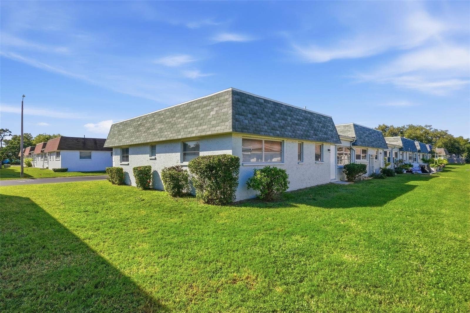 7035 MONTE CARLO N, Pinellas Park, FL 33781 Rear exterior of the villa overlooking the community's landscaped grounds.