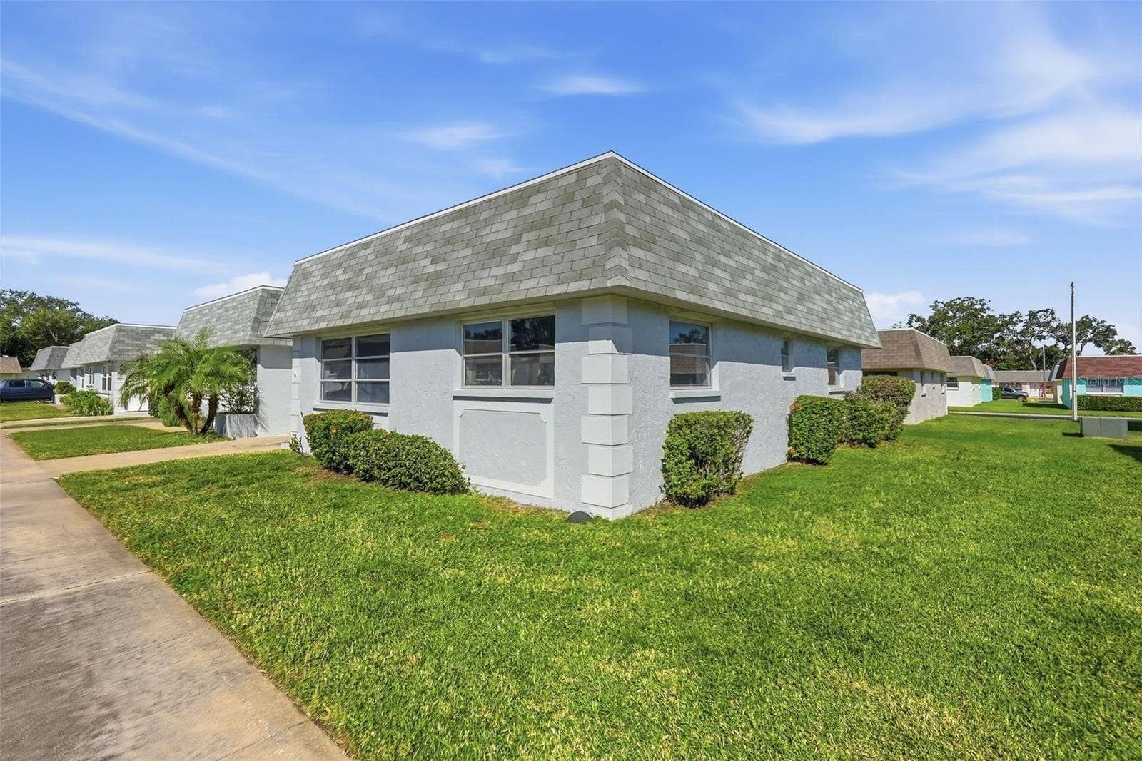 7035 MONTE CARLO N, Pinellas Park, FL 33781 dditional exterior view of this single-story end-unit villa with surrounding green space.
