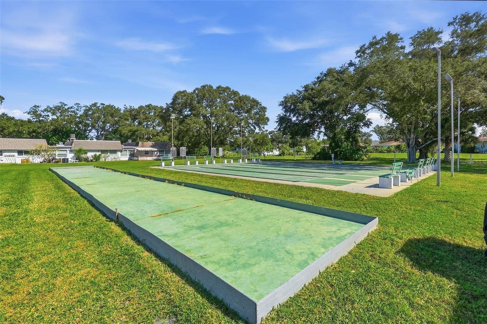 7035 MONTE CARLO N, Pinellas Park, FL 33781 utdoor shuffleboard courts surrounded by mature trees and green space.