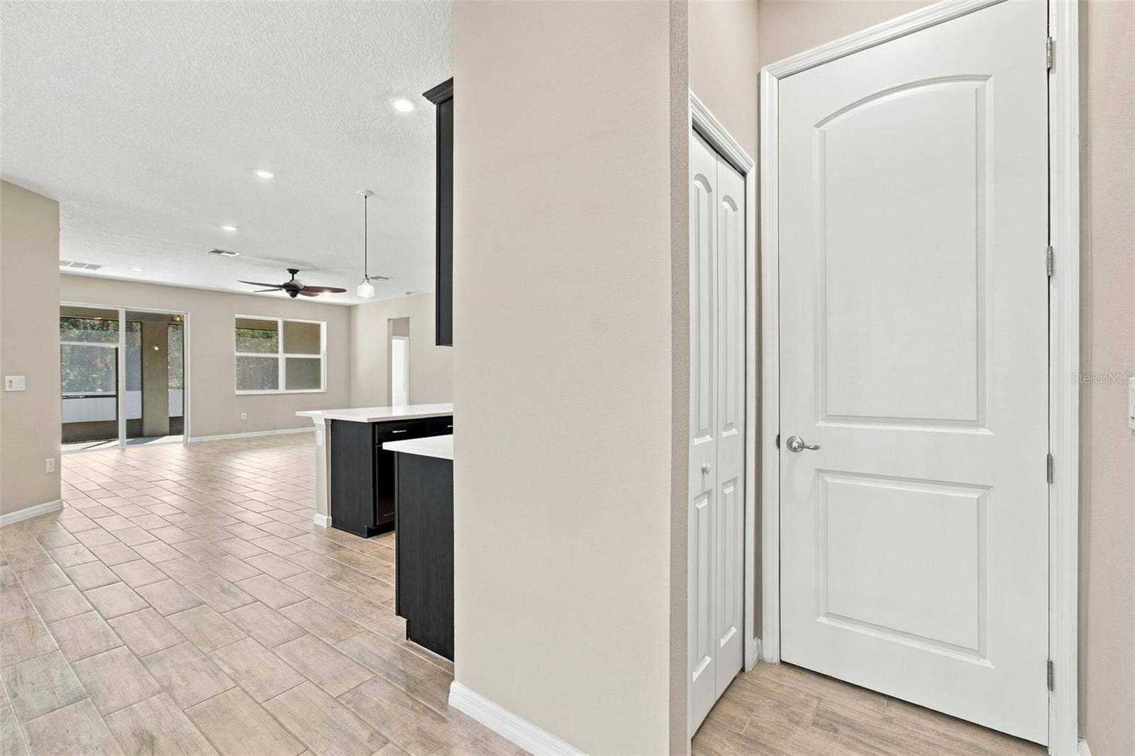 12417 BRICK COBBLESTONE DRIVE, Riverview, FL 33579 HVAC closet door and coat closet to the right, hallway heading to kitchen