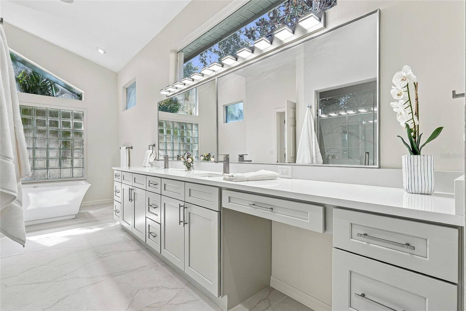 Modern and sleek primary bathroom vanity with make up area.