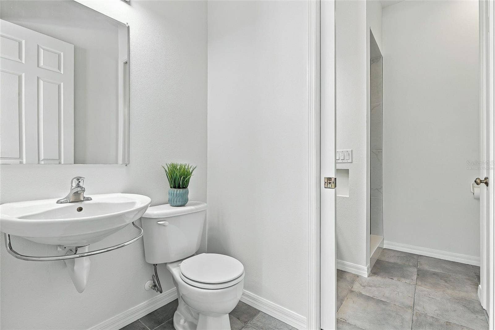 Dually-accessed full bathroom with a half bath easily accessible to the pool. Virtually staged.