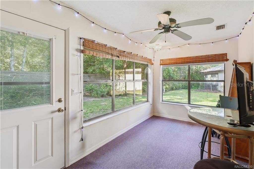 6268 W WESTON DRIVE, Crystal River, FL 34429 Enclosed rear porch with windows overlooking the backyard and sliding glass doors connecting to the interior.