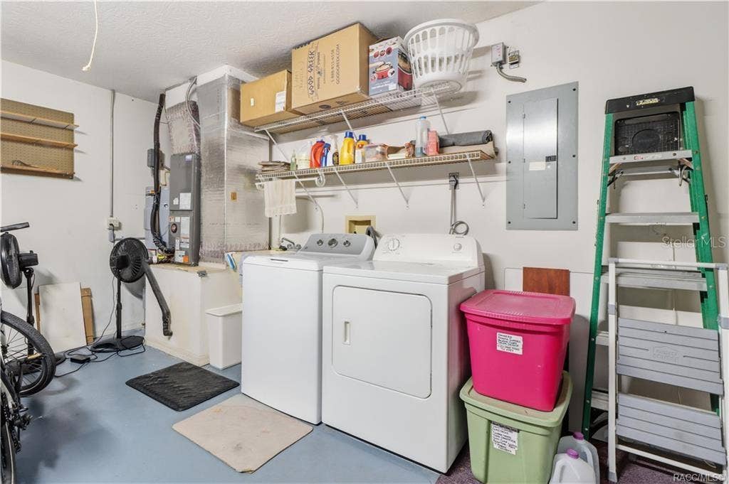 6268 W WESTON DRIVE, Crystal River, FL 34429 Garage laundry area with washer, dryer, overhead storage shelving, and additional storage space