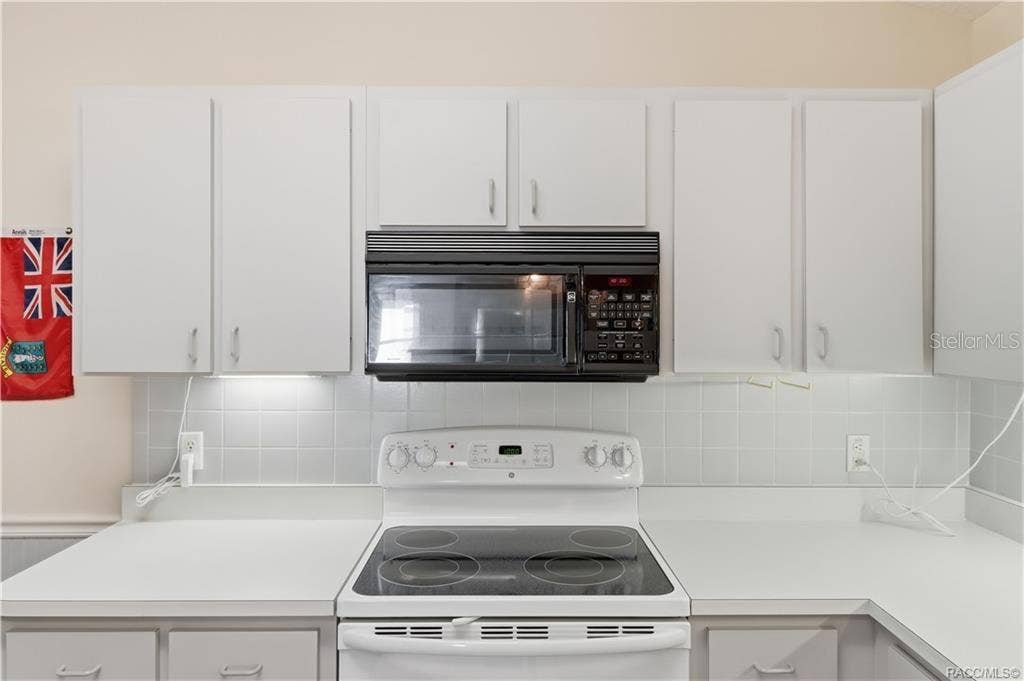 6268 W WESTON DRIVE, Crystal River, FL 34429 COOK UP SOMETHING GOOD! WHITE ELECTRIC RANGE, BUILT-IN MICROWAVE, TILE BACKSPLASH & surrounding cabinetry make meal preparation convenient!