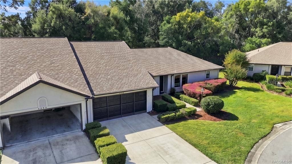 6268 W WESTON DRIVE, Crystal River, FL 34429 Aerial front view highlighting the home's attractive roofline, attached two-car garage, manicured landscaping, and cul-de-sac setting.