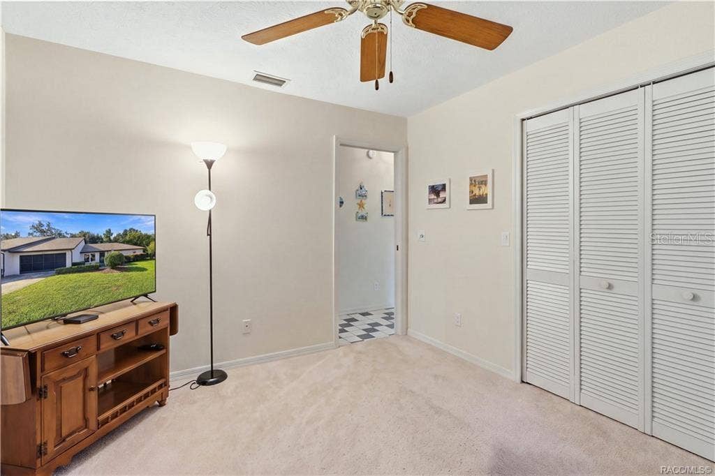 6268 W WESTON DRIVE, Crystal River, FL 34429 Guest bedroom with double-door closet, neutral finishes, and convenient access to the adjoining hallway.