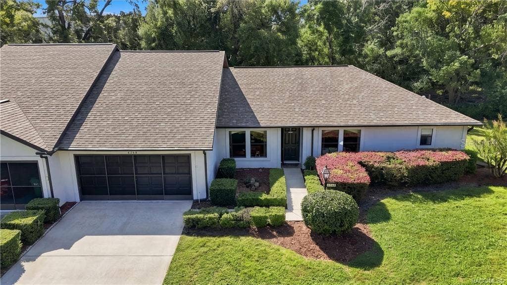 6268 W WESTON DRIVE, Crystal River, FL 34429 Front aerial view featuring the attached garage, welcoming entrance, neatly maintained landscaping, and attractive curb appeal.