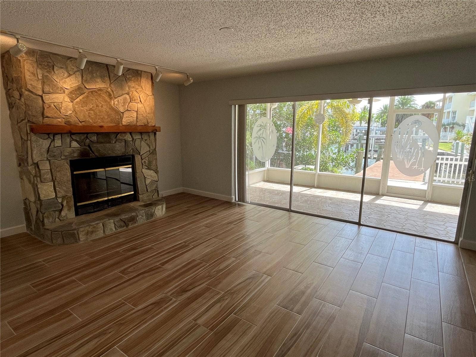 307 LA HACIENDA DRIVE, Indian Rocks Beach, FL 33785 Living room with covered patio access and view of the canal