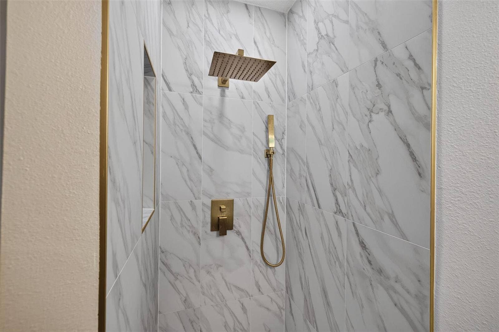 16107 SEA PINES DRIVE, Hudson, FL 34667 Step-in shower showcases beautiful new tile and stylish gold fixtures.