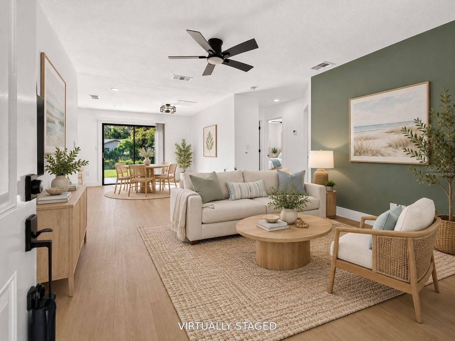 16107 SEA PINES DRIVE, Hudson, FL 34667 VIRTUALLY STAGED. Spacious living area featuring a modern sage green accent wall.