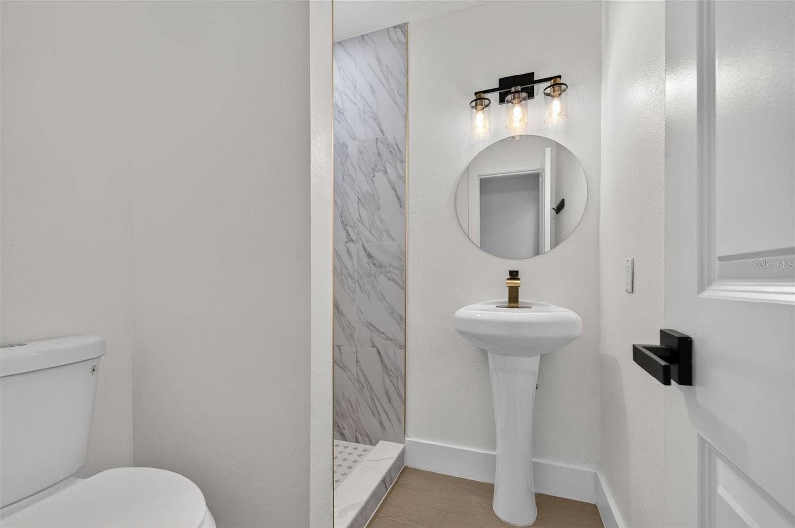 16107 SEA PINES DRIVE, Hudson, FL 34667 Beautifully updated ensuite bathroom featuring modern finishes and elegant gold accents.