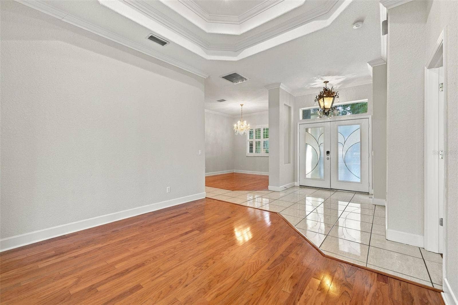 3916 VALRICO GROVE DRIVE, Valrico, FL 33594 Formal Living Room with Double Step Tray Ceiling adorned in Crown Molding! Real Wood Flooring & 5 1/4 Baseboards